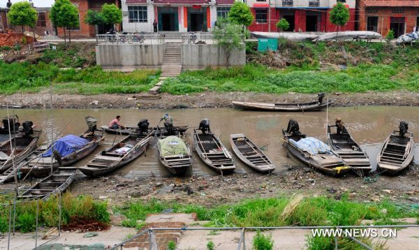 Photo taken on May 24, 2011 shows a row of fishing boats left along a stream near the Honghu Lake in Honghu City, central China's Hubei Province. Plagued by a severe drought which is spreading throughout China's southern regions, Honghu Lake has dwindled by a third in water surface and dropped down to less than 40 centimeters in its deepest place. (Xinhua/Hao Tongqian) (zn) 