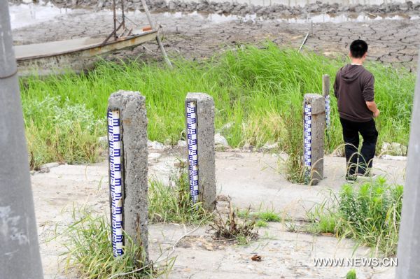 A resident passes by water level gauges at the bank of Honghu Lake in Honghu City, central China's Hubei Province, May 24, 2011. Plagued by a severe drought which is spreading throughout China's southern regions, Honghu Lake has dwindled by a third in water surface and dropped down to less than 40 centimeters in its deepest place. (Xinhua/Hao Tongqian) (zn) 