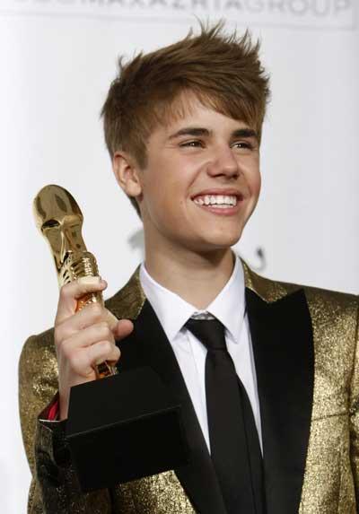 Singer Justin Bieber poses in the photo room with his Top New Artist award at the 2011 Billboard Music Awards show in Las Vegas.