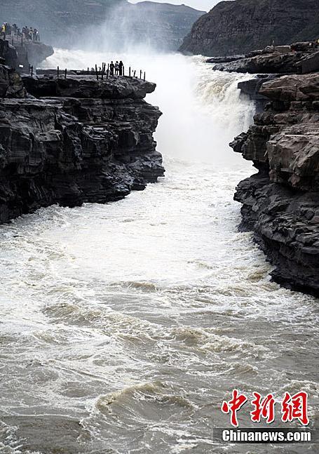 Visitors enjoy the splendid view of Hukou Waterfall on Yellow River in Yichuan county, Shaanxi province near the Shaanxi-Shanzi border on May 25, 2011. [chinanews.com]