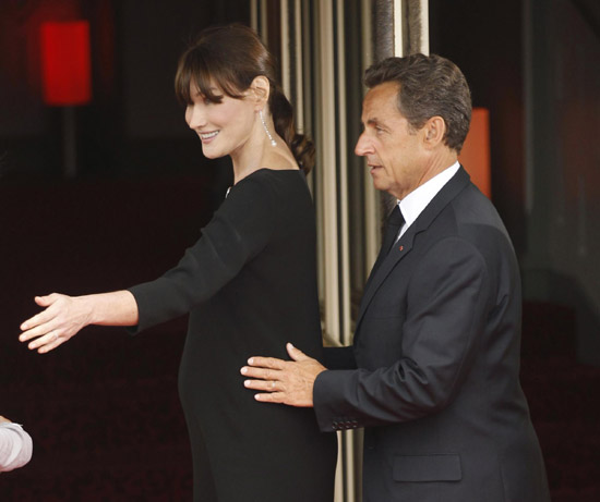 French President Nicolas Sarkozy puts his hands upon his pregnant wife Carla Bruni-Sarkozy as they greet leaders for dinner at the G8 Summit in Deauville May 26, 2011.[Agencies] 