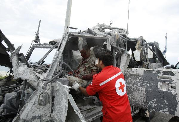 A Lebanese Red Cross renders help to a wounded Italian U.N peacekeeper in his vehicle at Remaily village near the southern Lebanese port city of Sidon May 27, 2011. [Xinhua/Reuters Photo]