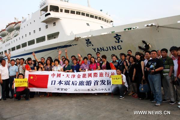 Tourists pose for a group photo before boarding on a ship in Tianjin port of north China's Tianjin Municipality, May 29, 2011. [Xinhua/Hu Ming]