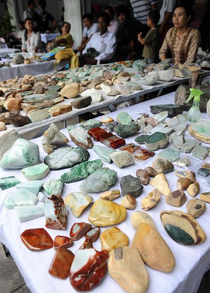 Myanmar gem merchants sell raw stones at a jewelry shopping center in Ruili City, Dai-Jingpo Autonomous Prefecture of Dehong, southwest China's Yunnan Province, May 29, 2011. Since the 1990s, Ruili has dedicated itself to developing the jewelry industry. There are over 6000 shops and 40,000 professionals engaged in jewelry industry in Ruili, with the annual trading volume reaching 2 billion RMB yuan. [Xinhua/Lin Yiguang]