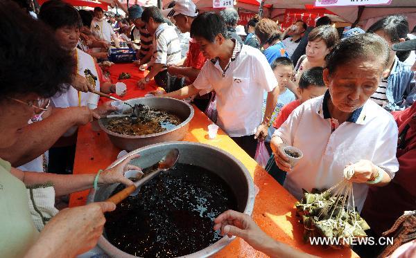 Citizens queue up to taste traditional snacks made of rice at the traditional rice food festival held in Taipei, south China's Taiwan, May 29, 2011. A traditional rice food festival kicked off in Taipei on Sunday, attracting many citizens to taste delicious snacks.
