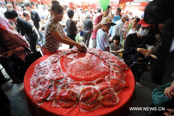 Turtle-shaped rice snacks are distributed to citizens at the traditional rice food festival held in Taipei, south China's Taiwan, May 29, 2011. A traditional rice food festival kicked off in Taipei on Sunday, attracting many citizens to taste delicious snacks.