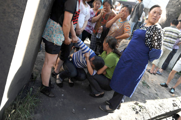 Relatives of trapped miners cry outside a flooded coal mine in Jinyang new district of Guiyang city, Southwest China's Guizhou province, May 29, 2011.