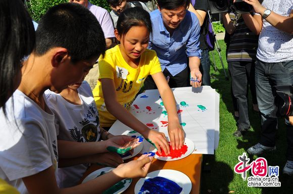 UNICEF project benefitted students from Henan Province paint little footprints on the sheet, signalling the progressing cause of child welfare in China. [Pierre Chen / China.org.cn]