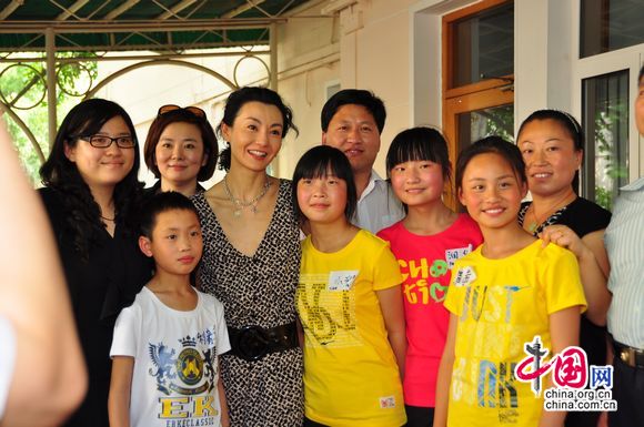Maggie Cheung pose for photo with children from Henan Province who have been benefitted from UNICEF&apos;s child welfare programmes. [Pierre Chen / China.org.cn]