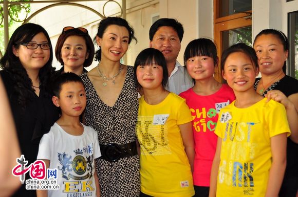 Maggie Cheung pose for photo with children from Henan Province who have been benefitted from UNICEF's child welfare programmes. [Pierre Chen / China.org.cn]