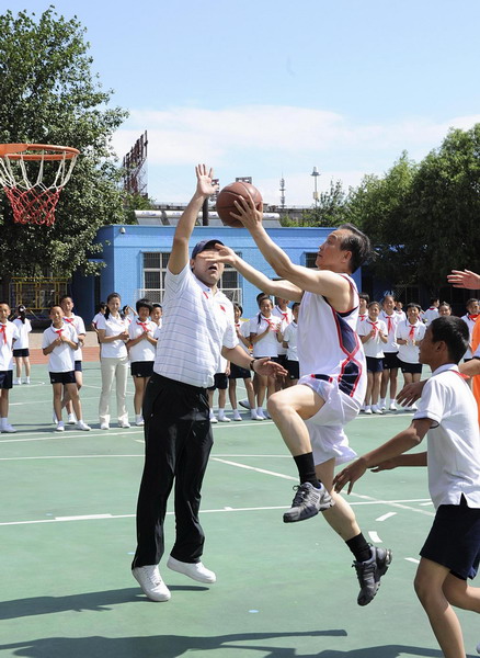 Premier Wen Jiabao (R2) makes a layup during a basketball game at a PE class in Shibalidian primary school in Chaoyang district, Beijing, May 31, 2011. [Xinhua]