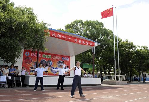Premier Wen Jiabaopays a visit to the school Tuesday, where he joined students in a basketball game and encouraged children to stay healthy by participating in sports and other physical activities. [Xinhua]