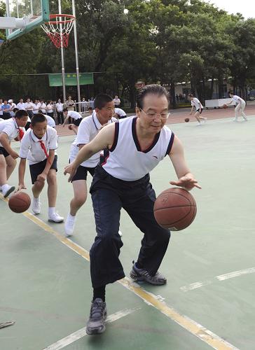 Premier Wen Jiabao plays basketball at a PE class in Shibalidian primary school in Chaoyang district, Beijing, May 31, 2011. [Xinhua] 