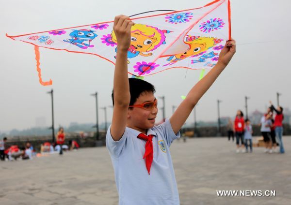 A boy with impaired sight flies a kite on the city wall of Nanjing, capital of east China&apos;s Jiangsu Province, May 31, 2011. About 80 students from the school for blind children in Nanjing took part in an celebration activity of the upcoming International Children&apos;s Day on Tuesday by flying the kites they made. [Xinhua]