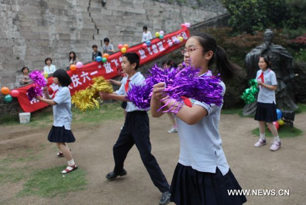 Children with impaired sight perform near the city wall in Nanjing, capital of east China&apos;s Jiangsu Province, May 31, 2011. About 80 students from the school for blind children in Nanjing took part in an celebration activity of the upcoming International Children&apos;s Day on Tuesday by flying the kites they made. [Xinhua]