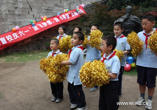 Children with impaired sight perform near the city wall in Nanjing, capital of east China&apos;s Jiangsu Province, May 31, 2011. About 80 students from the school for blind children in Nanjing took part in an celebration activity of the upcoming International Children&apos;s Day on Tuesday by flying the kites they made. [Xinhua]