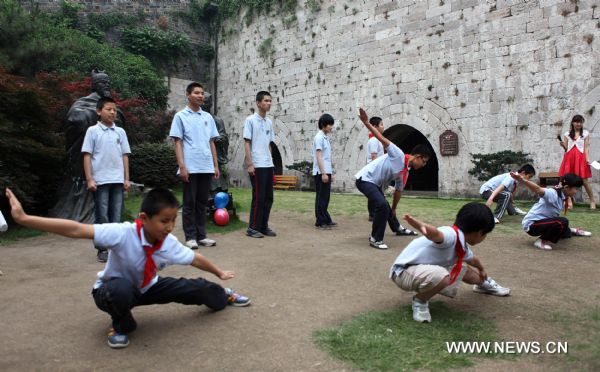 Children with impaired sight perform near the city wall in Nanjing, capital of east China&apos;s Jiangsu Province, May 31, 2011. About 80 students from the school for blind children in Nanjing took part in an celebration activity of the upcoming International Children&apos;s Day on Tuesday by flying the kites they made. [Xinhua]