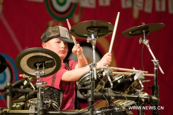 Autistic boy Chao Chao plays the drums at the Chaoyang Theater in Beijing, capital of China, May 31, 2011. An art festival was held here to celebrate the International Children&apos;s Day. [Xinhua]