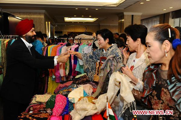 Women pick up goods during a charity sale for disaster areas hit by the earthquake and tsunami at Chinese embassy to Japan in Tokyo, captial of Japan, May 31, 2011. Chinese embassy to Japan held a Chinese culture fair and the charity sale on Tuesday. [Xinhua] 