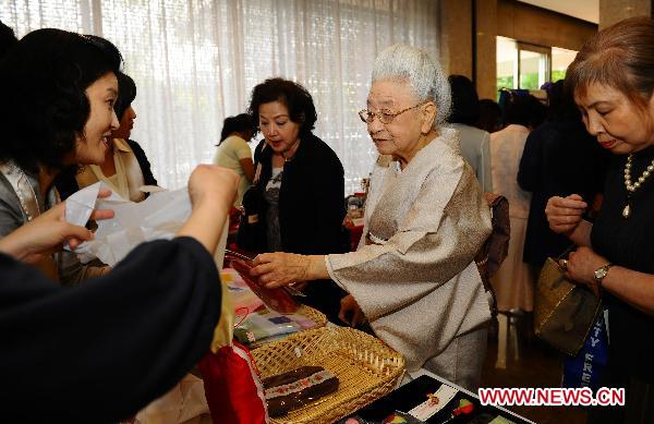 Women pick up goods during a charity sale for disaster areas hit by the earthquake and tsunami at Chinese embassy to Japan in Tokyo, captial of Japan, May 31, 2011. Chinese embassy to Japan held a Chinese culture fair and the charity sale on Tuesday. [Xinhua]