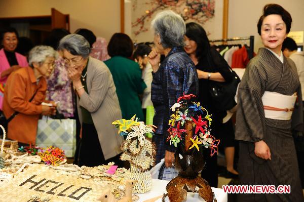 Women pick up goods during a charity sale for disaster areas hit by the earthquake and tsunami at Chinese embassy to Japan in Tokyo, captial of Japan, May 31, 2011. Chinese embassy to Japan held a Chinese culture fair and the charity sale on Tuesday. [Xinhua] 