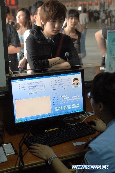 Police officer issues a passenger who forgetS to bring along his ID card a temporary identity certification at the railway station in Hangzhou, capital of east China&apos;s Zhejiang Province, June 1, 2011. Chinese rail ticket offices started selling high-speed train tickets with passenger&apos;s name and ID numbers from June 1, 2011. [Xinhua]