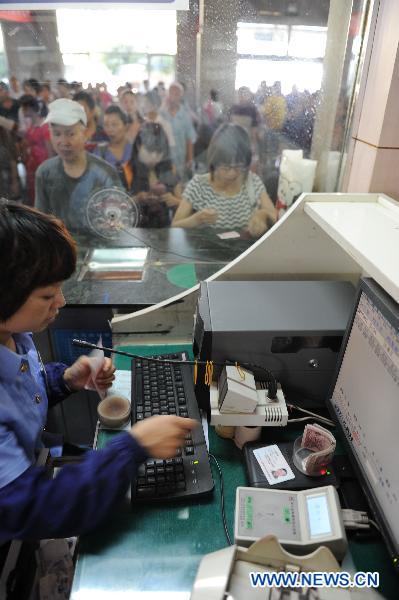 Staff member verifies the ID card of a passenger while selling ticket at the railway station in Shijiazhuang of north China&apos;s Hebei Province, June 1, 2011. Chinese rail ticket offices started selling high-speed train tickets with passenger&apos;s name and ID numbers from June 1, 2011. [Xinhua]