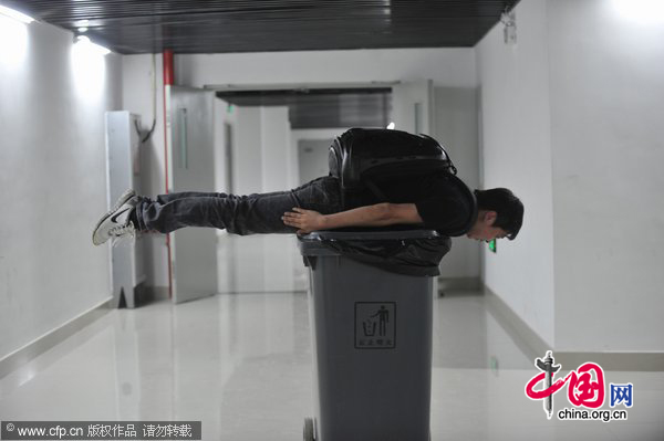 A man planks on a trash can in Shenyang, Northeast China&apos;s Liaoning province, May 31, 2011. [Photo/CFP] 