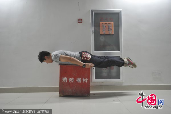 A man planks on a fire-fighting equipment box in Shenyang, Northeast China&apos;s Liaoning province, May 31, 2011. [Photo/CFP]