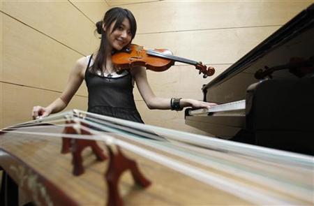 Taiwanese musician Shara Lin Yi-Hsin, 25, poses for a photograph during an interview with Reuters in Taipei May 25, 2011. A video of Lin, which showed her performing Taiwanese singer Jolin Tsai's ''Dancing Diva'' by simultaneously playing the piano, violin, and zither, has attracted wide internet attention.