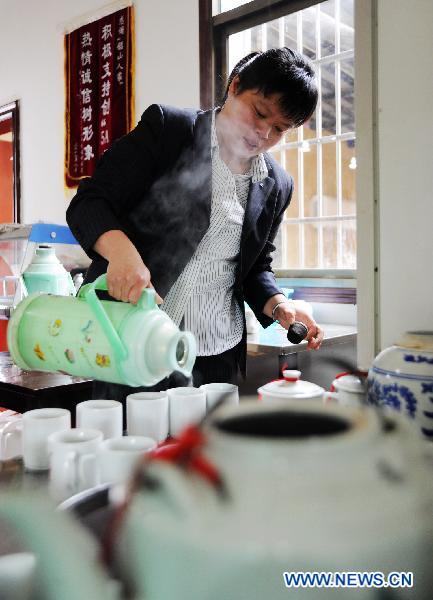Hostess Peng Xuequn prepares tea for customers at her Shaoshan Ren Jia, or literally Shaoshan-Household Restaurant, in Shaoshan, central China's Hunan Province, May 24, 2011.