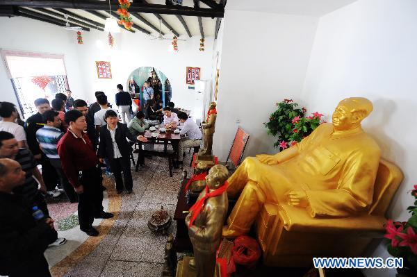 Hostess Peng Xuequn (R, front) introduces customers the statues of Chairman Mao at her Shaoshan Ren Jia, or literally Shaoshan-Household Restaurant, in Shaoshan, central China's Hunan Province, May 24, 2011. [Xinhua/Long Hongtao] 