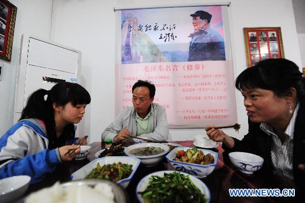 Hostess Peng Xuequn (R) has supper together with her husband and her daughter at Shaoshan Ren Jia, or literally Shaoshan-Household Restaurant, in Shaoshan, central China's Hunan Province, May 24, 2011. [Xinhua/Long Hongtao] 