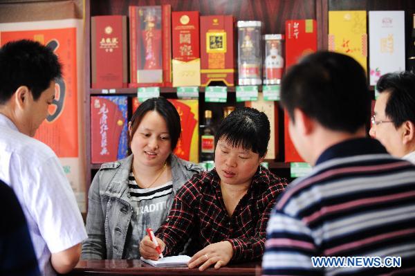 Hostess Peng Xuequn (C) talks with customers at her Shaoshan Ren Jia, or literally Shaoshan-Household Restaurant, in Shaoshan, central China's Hunan Province, May 24, 2011. [Xinhua/Long Hongtao] 