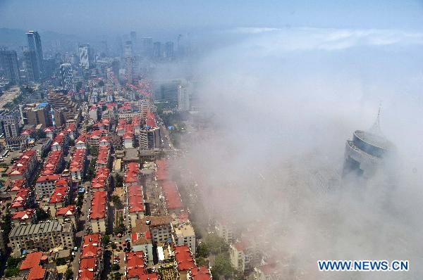 Advection fog surrounds buildings on the sea front in Yantai City of east China's Shandong Province, June 1, 2011. Advection fog appeared in Yantai on Wednesday, drifting above the city and presenting a beautiful view. [Xinhua/Guo Xulei] 