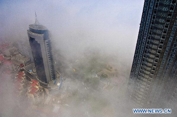 Advection fog surrounds buildings on the sea front in Yantai City of east China's Shandong Province, June 1, 2011. Advection fog appeared in Yantai on Wednesday, drifting above the city and presenting a beautiful view. [Xinhua/Guo Xulei]