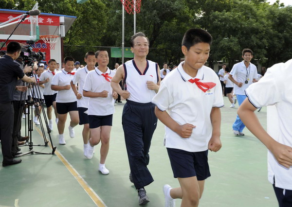 Premier Wen Jiabao (C) is seen during a warm-up activity at a PE class in Shibalidian primary school in Chaoyang district, Beijing, May 31, 2011.