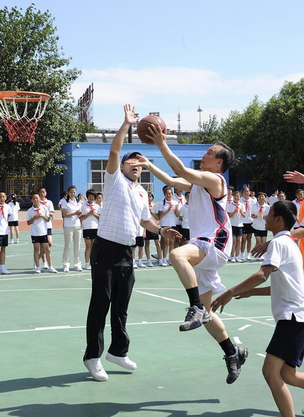 Premier Wen Jiabao (R2) makes a layup during a basketball game at a PE class in Shibalidian primary school in Chaoyang district, Beijing, May 31, 2011. [Photo/Xinhua]