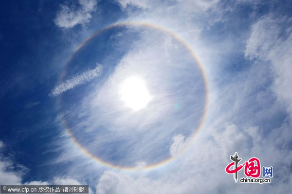 A halo appears around the sun over children performing gymnastic exercises during a local school sports meet in Minami-Ashigara, Kanagawa Prefecture, about 70km southwest of Tokyo, on Tuesday, May 31, 2011. The atmospheric phenomenon called a 22-degree halo of the son is caused when sunlight is refracted in hexagonal ice crystals suspended in the atmosphere. [CFP]