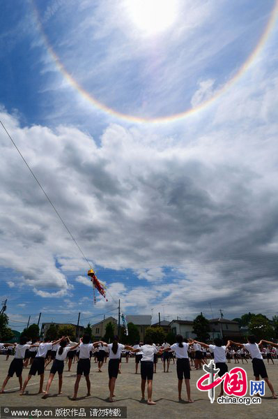 A halo appears around the sun over children performing gymnastic exercises during a local school sports meet in Minami-Ashigara, Kanagawa Prefecture, about 70km southwest of Tokyo, on Tuesday, May 31, 2011. The atmospheric phenomenon called a 22-degree halo of the son is caused when sunlight is refracted in hexagonal ice crystals suspended in the atmosphere. [CFP]