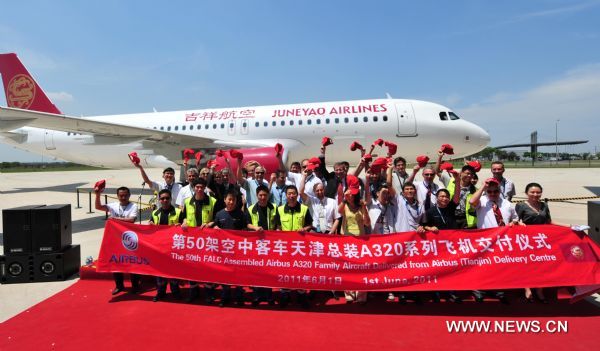 Airbus executives and engineers pose for group photo during the delivery of an Airbus A320 series plane in Tianjin, north China, June 1, 2011. The 50th Airbus A320 series plane that rolls off Tianjian assembly line was delivered to Juneyao Airlines here Wednesday. The Airbus 320 assembly line in Tianjin, the first for Airbus outside Europe, is a joint venture between Airbus, the Aviation Industry Corp. of China (AVIC), and Tianjin Bonded Zone Investment Co., and went into production in September 2008. (Xinhua/Liu Haifeng) (ljh) 