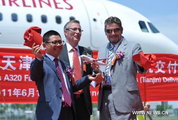 Juneyao Airlines Chairman Wang Junjin (L) receives an A320 series model plane from airbus executives during the delivery of an Airbus A320 series plane in Tianjin, north China, June 1, 2011. The 50th Airbus A320 series plane that rolls off Tianjian assembly line was delivered to Juneyao Airlines here Wednesday. The Airbus 320 assembly line in Tianjin, the first for Airbus outside Europe, is a joint venture between Airbus, the Aviation Industry Corp. of China (AVIC), and Tianjin Bonded Zone Investment Co., and went into production in September 2008. (Xinhua/Liu Haifeng) (ljh) 