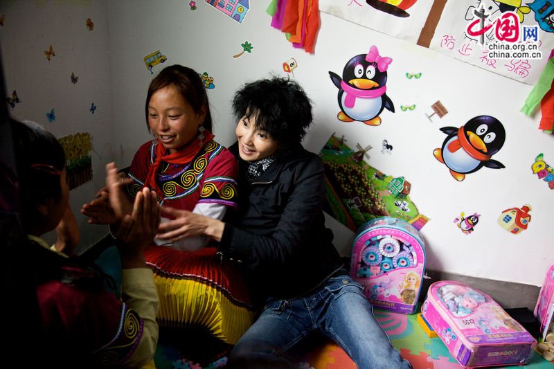 Maggie Cheung, UNICEF Ambassador in China plays with girls of Yi ethnic group at the Youth Center in Liangshan. [UNICEF]