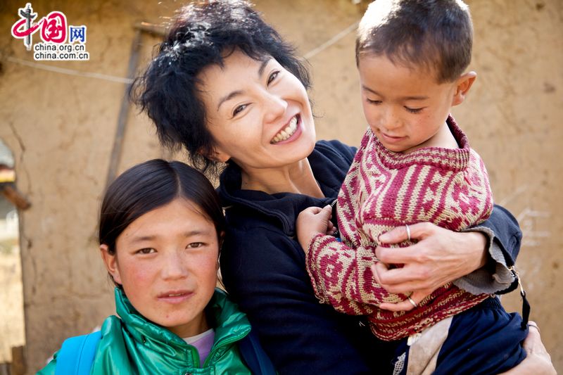 Maggie Cheung, UNICEF Ambassador in China visits a parentless sibling. Learning that their parents died long time ago, Maggie hugged the boy, giving him encouragement. [UNICEF]