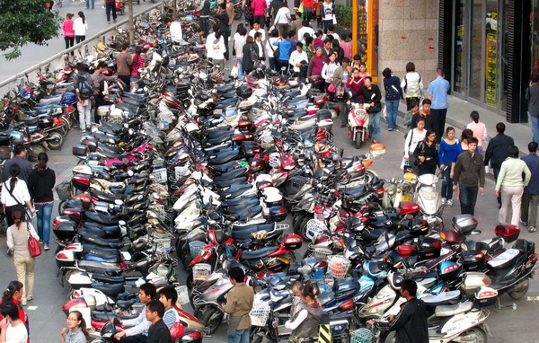 Electric scooters are parked on a sidewalk in Zhengzhou, the capital of Central China&apos;s Henan province, in this file photo taken Sept 22, 2010.