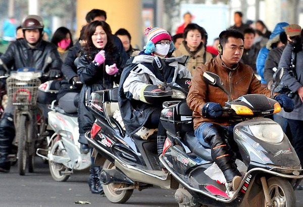 People ride electric scooters in Zhengzhou, Central China&apos;s Henan province, in this file photo taken Dec 2, 2009. [Xinhua] 