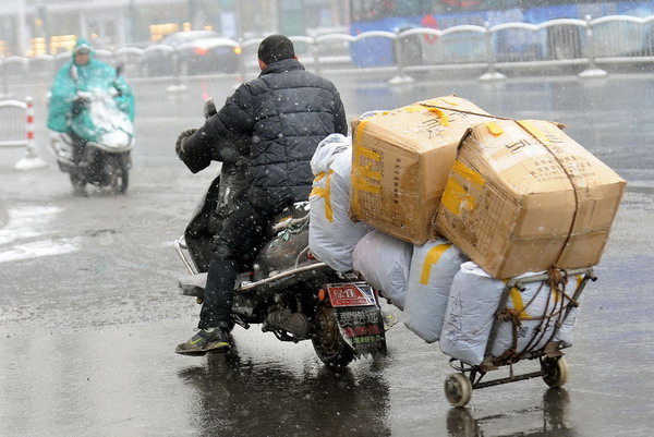 A man hauls a trailer with his electric scooter in Zhengzhou, Central China&apos;s Henan province, in this file photo taken Feb 28, 2011. [Xinhua] 