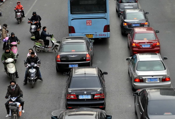 People ride electric scooters alongside automobiles in Zhengzhou, Central China&apos;s Henan province, in this file photo taken Dec 31, 2010. [Xinhua] 