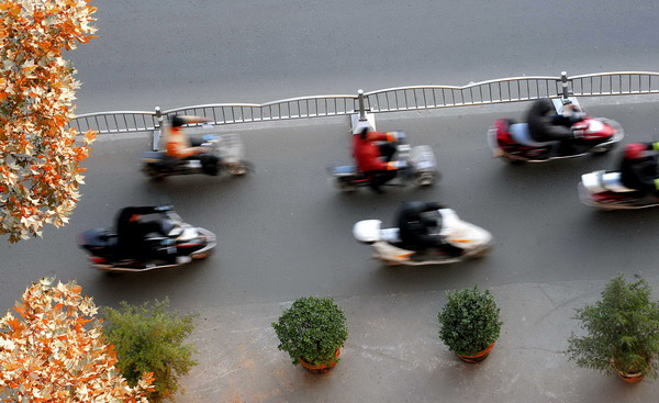 People ride electric scooters in Zhengzhou, Central China&apos;s Henan province, in this file photo taken Dec 2, 2009. [Xinhua] 