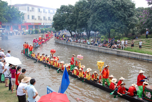 Villagers look on as participants row their boats on a river in Zhucun village in Guangzhou, South China&apos;s Guangdong province, June 2, 2011. [Xinhua] 